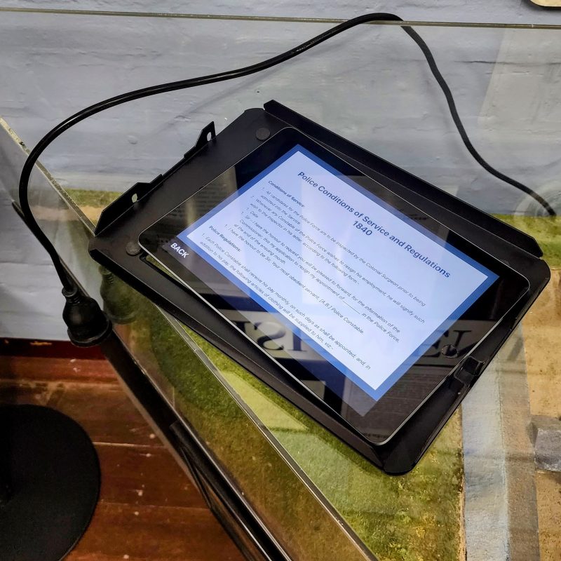 An iPad museum kiosk being installed on a stand